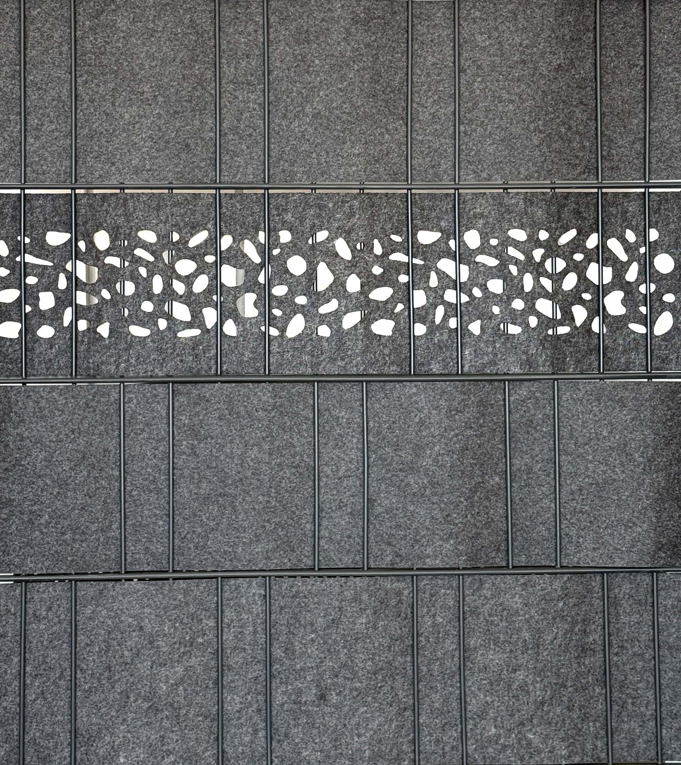 Detailansicht eines Doppelstabmattenzauns mit grauen Sichtschutzstreifen und einem perforierten Florenz Leo Einzelstreifen Laser im Florenz Bubble Design von Zaundruck als dekorativem Highlight im mittleren Zaunfeld, 2,6 m breit