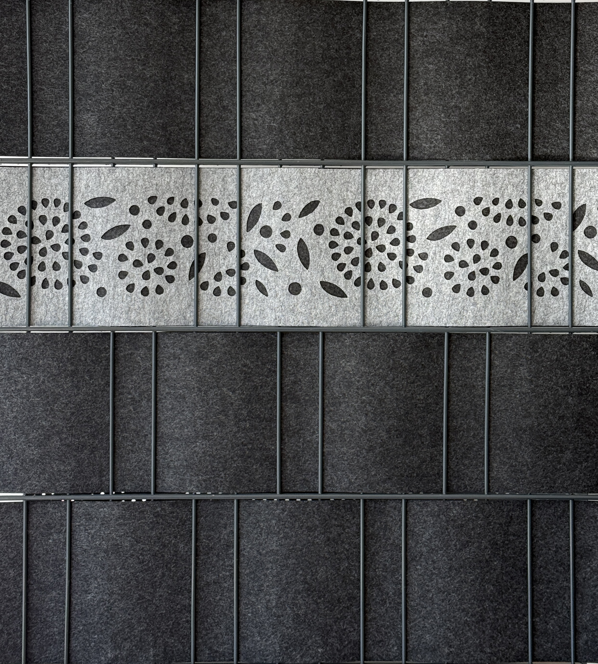 Detailansicht des Zaundruck Sichtschutzstreifens Venezia Flower mit gelasertem Blumenmuster, als einzelner 2,60 m Akzentstreifen im Doppelstabmattenzaun montiert.