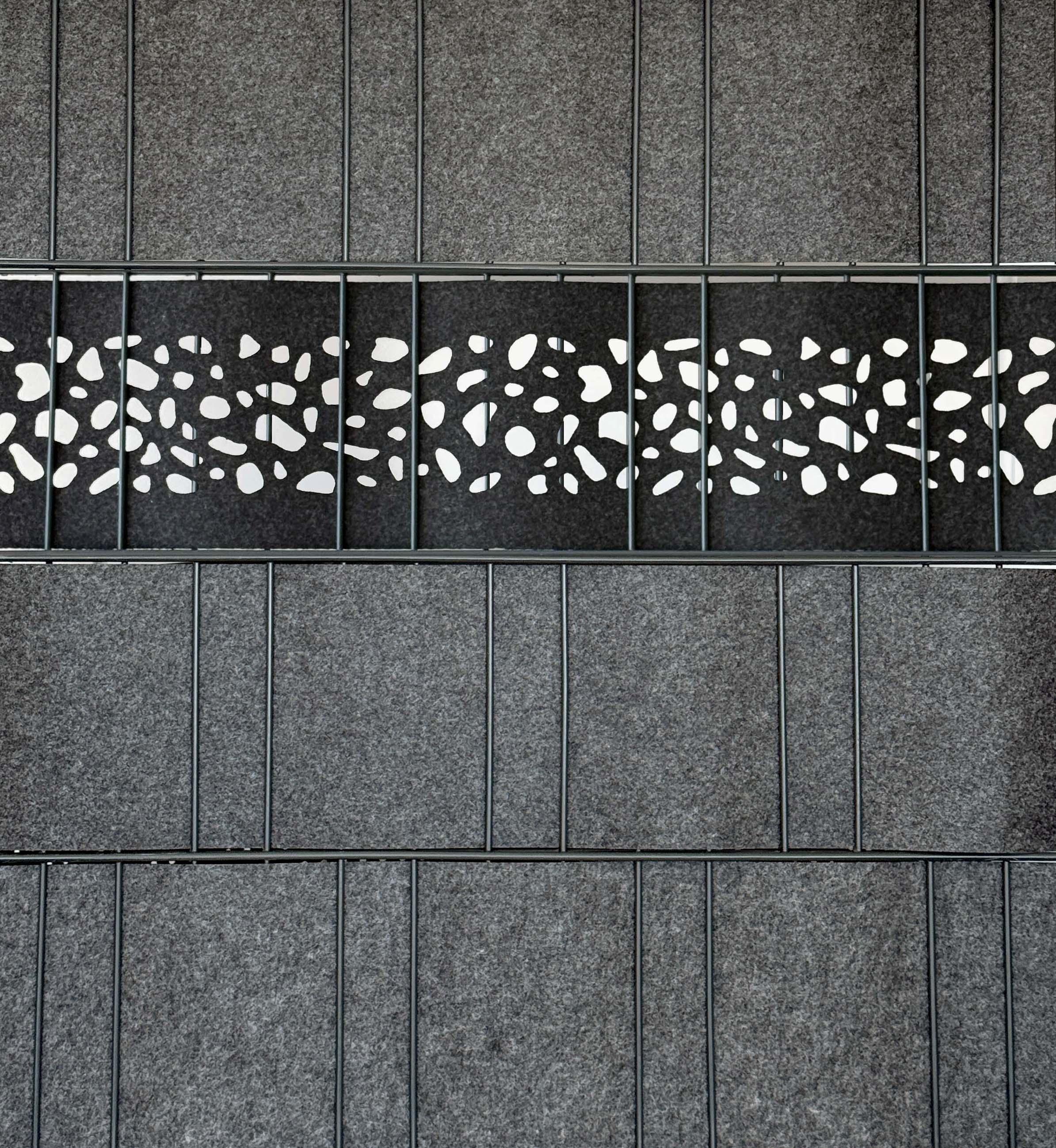 Sichtschutzstreifen Milano Leo von Zaundruck, gelaserter Einzelstreifen 2,60 m x 19 cm mit perforiertem Dekorband für Doppelstabmattenzaun, kombiniert mit einfarbigen Streifen im Gartenzaun.